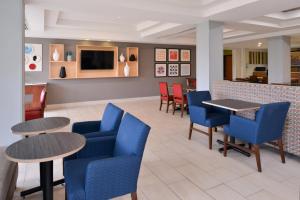 un ristorante con sedie e tavoli blu e un bancone di Holiday Inn Express Mineral Wells, an IHG Hotel a Parkersburg