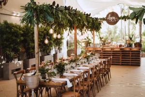 a row of tables in a room with plants at Cairns Harbourside Hotel in Cairns