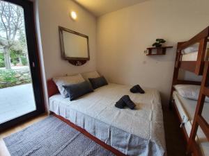 małą sypialnię z łóżkiem i lustrem w obiekcie Green Garden Gajac Apartman w mieście Skunca