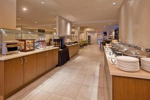 a restaurant with a long counter with plates on it at Holiday Inn Vancouver-Centre Broadway, an IHG Hotel in Vancouver