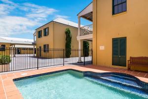 a swimming pool in front of a house at Ballina Heritage Inn in Ballina