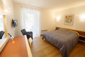 - une chambre avec un lit, un bureau et une fenêtre dans l'établissement Logis Hôtel L'Auzeraie, à Ax-les-Thermes