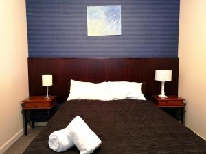 una camera con un letto con due comodini e due lampade di 45 on Avenal Motel a Invercargill