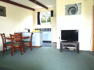 a living room with a table and a television at 45 on Avenal Motel in Invercargill