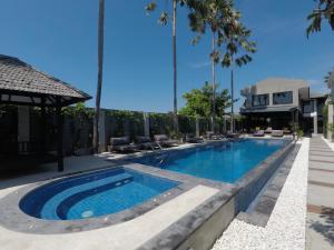 a swimming pool in a backyard with palm trees at Rhythm & Rumble in Canggu