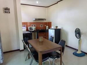 a kitchen with a table and chairs in a room at Saithong Resort in Udon Thani