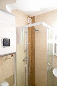 eine Dusche mit Glastür im Bad in der Unterkunft Studio Alexandra in Galaţi