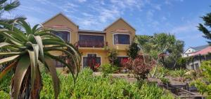 a yellow house with a lot of plants at Villa Tartaruga in Sedgefield