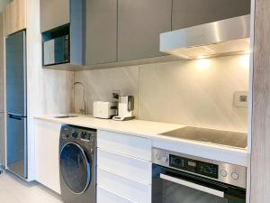 cocina con lavadora y fregadero en Menlyn Maine Residences - Central Park with king sized bed, en Pretoria