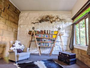 a room with a book shelf and a chair at Wyndford Holiday Farm in Fouriesburg
