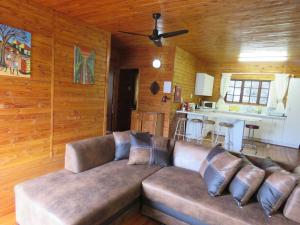 a large couch in a living room with wooden walls at Impala Niezel Lodge & Guest House in Hazyview