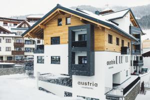 a building in the winter with snow at Austria Aparthotel in Fiss
