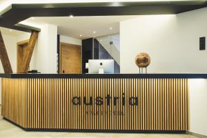 an office lobby with a reception desk with a sign on it at Austria Aparthotel in Fiss