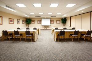 una sala conferenze con tavoli, sedie e uno schermo di Holiday Inn Express Airport East by IHG a Salt Lake City