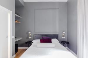 1 dormitorio con 1 cama blanca y 2 sillas negras en Suites by Chloe, en Roma