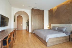 a bedroom with a large bed and a desk at Oriental Danang in Danang