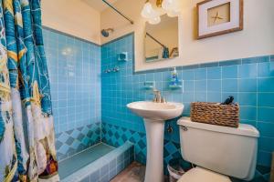 a blue tiled bathroom with a sink and a toilet at Hainsley Apartments - Walk to Wilton Drive in Fort Lauderdale