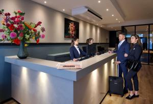 a group of people standing at a reception desk at Brasss Hotel Suites in Haarlem