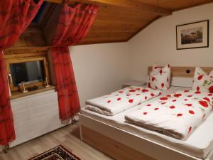 um quarto com uma cama com almofadas vermelhas e brancas em Apart Ponholz em Hart im Zillertal