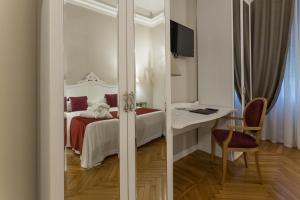 a bedroom with a bed and a desk and a chair at Mediterraneo Emotional Hotel & Spa in Santa Margherita Ligure