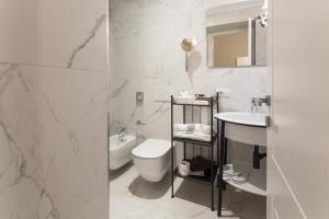 a white bathroom with a toilet and a sink at Mediterraneo Emotional Hotel & Spa in Santa Margherita Ligure