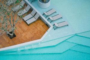 an overhead view of a pool with tables and chairs at Citygate Kamala Resort and Residence in Kamala Beach