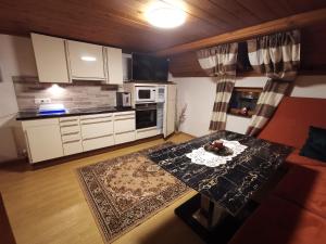 uma sala de estar com uma mesa e uma cozinha em Apart Ponholz em Hart im Zillertal