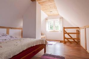 a bedroom with a bed and a window and a staircase at Agroturystyka Leśna Dolinka in Narty