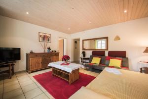 a living room with a couch and a tv at Holiday Apartment Beauregard in Brienz