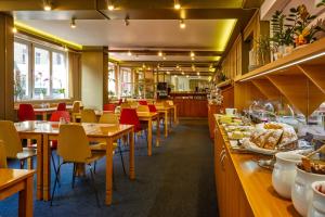 布拉格的住宿－查爾斯中央酒店，餐厅设有木桌和红色椅子
