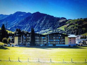 duży budynek na polu przed górą w obiekcie Apartment Luna incl Summercard Zell am See Kaprun w Kaprunie