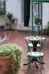 a patio with two chairs and a table and potted plants at VILLA LA DOGANA in Lucca