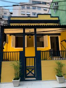 a yellow and blue building with a balcony at Apartamento de 1 quarto in Rio de Janeiro