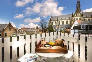 een dienblad met eten bovenop een wit hek bij Haarlem Hotel Suites in Haarlem