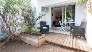 a porch with chairs and a table on a house at Grand T1 avec terrasse à 5min des plages et 400m de St Gilles Les Bains in Saint-Gilles les Bains