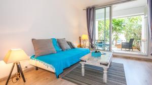 a bedroom with a bed and a large window at Grand T1 avec terrasse à 5min des plages et 400m de St Gilles Les Bains in Saint-Gilles les Bains +4 photos