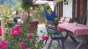 a patio with a table and some pink flowers at Pension Mühlbauer in Bayrischzell
