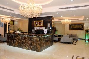 a lobby with a bar and chandeliers at Hotel AlYosr Royal in Makkah