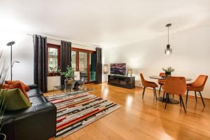 ein Wohnzimmer mit einem schwarzen Sofa und einem Tisch in der Unterkunft Tjuvholmen I, As Home in Oslo