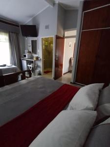ein großes Schlafzimmer mit einem großen Bett und einer Küche in der Unterkunft Stew s Room in Polokwane
