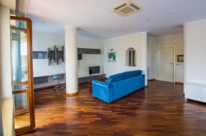 un soggiorno con un divano blu e un palo di Appartamento Cadore a San Benedetto del Tronto