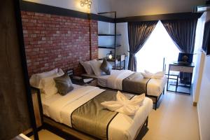 a hotel room with two beds and a brick wall at Vits Select Kudro Destinn in Mangalore