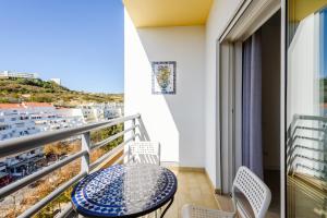 a balcony with a table and chairs and a view of the ocean at Amazing apartment in Albufeira in Albufeira