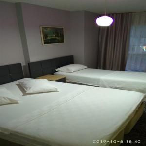 una habitación de hotel con 2 camas y una lámpara en The Tuyap Rainbow Suites en Beylikduzu