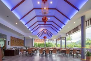 a dining hall with tables and chairs and a blue ceiling at Phuket La Siesta in Nai Harn Beach