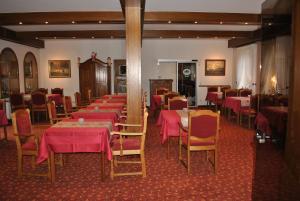 ein Esszimmer mit Tischen, Stühlen und rosa Tischdecken in der Unterkunft Hotel Seeschwalbe in Cuxhaven