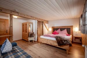 a bedroom with a bed with red pillows at Grittlmühle Chalet Ferienwohnungen in Brixen im Thale