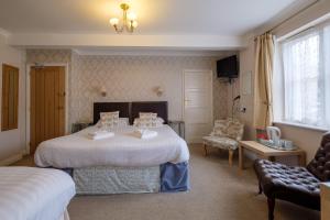 a hotel room with two beds and a chair at Newport Quay in Newport