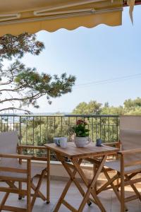 - une table et des chaises en bois sur une terrasse avec vue dans l'établissement Alexandros Maisonettes & Apartments, à Nea Moudania