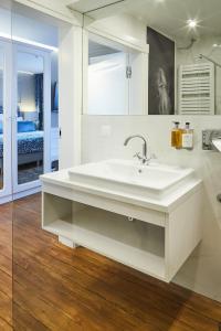 a white bathroom with a sink and a bedroom at Willa Stara Wozownia in Tarnowo Podgórne